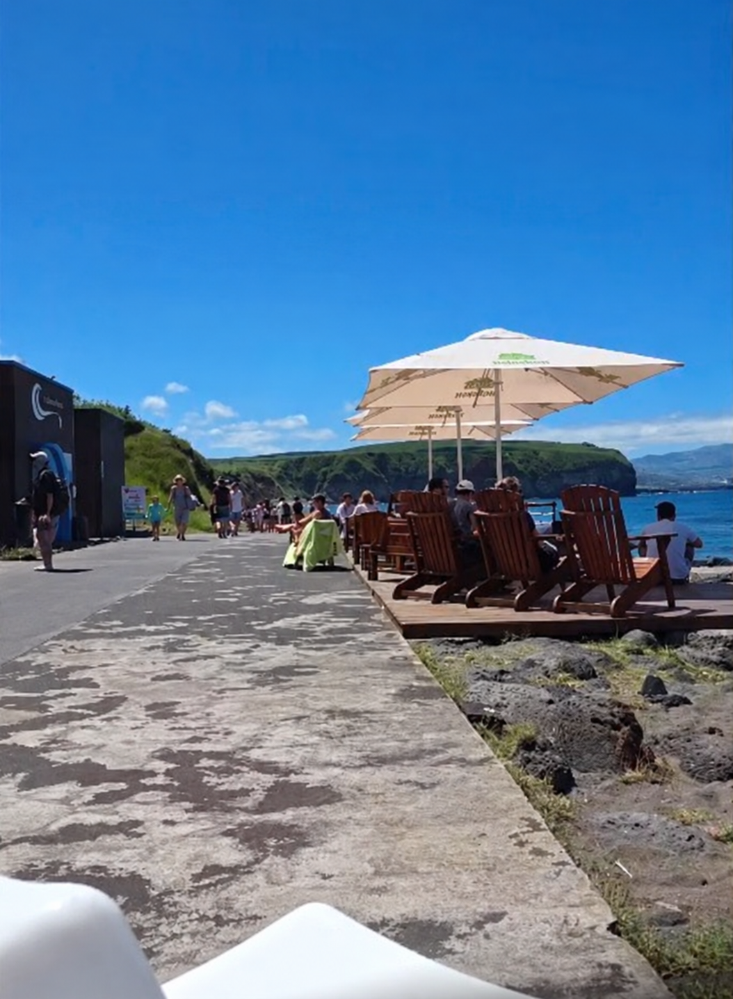 Cadeiras de madeira e guarda-sóis na esplanada do Tuká Tulá junto ao passeio de Santa Bárbara