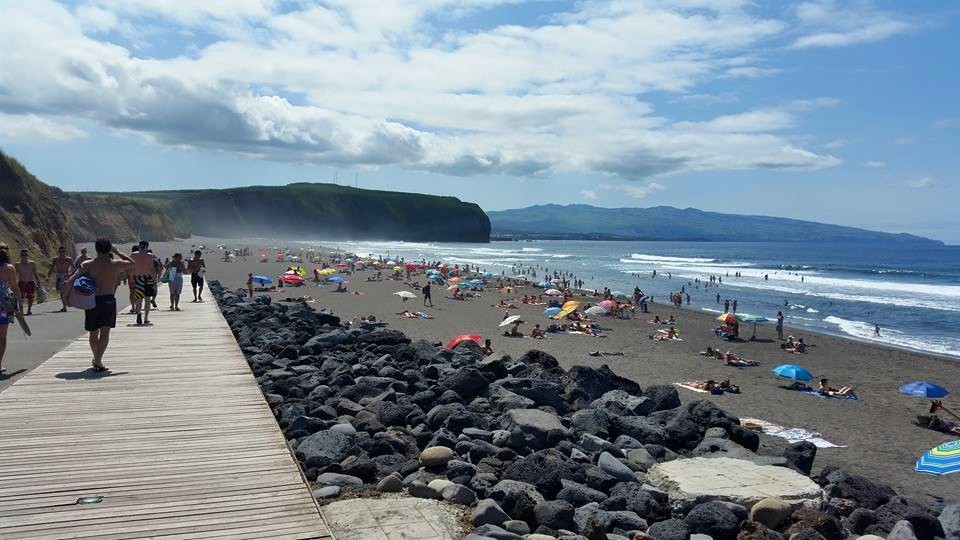 Banhistas no areal de Santa Bárbara junto ao passadiço e às rochas vulcânicas