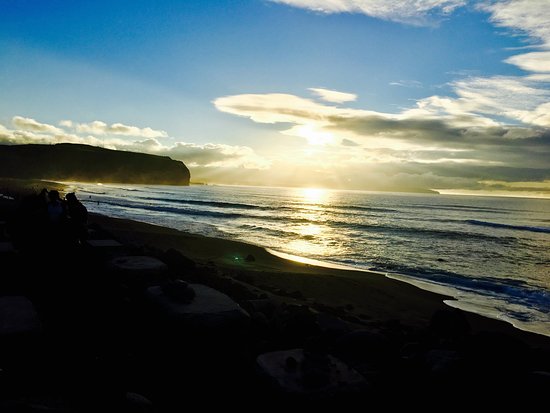 Pôr do sol sobre o mar e a areia escura de Santa Bárbara